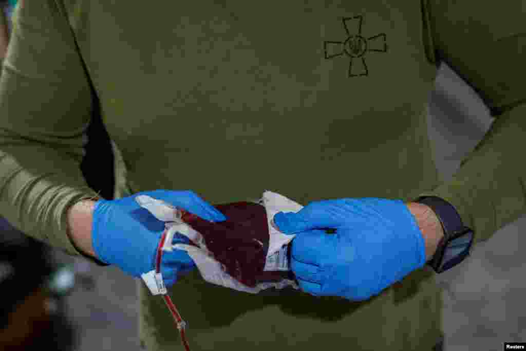 Un médico prepara una bolsa de sangre para transfusión mientras asiste a los soldados heridos en los combates cerca de la ciudad de Chasiv Yar, en la región de Donetsk, Ucrania, el 1 de julio. 2024.&nbsp;
