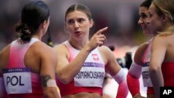 Krystsina Tsimanouskaya, of Poland, gestures as she talks with teammates following their women's 4x100-meter relay heat at the 2024 Summer Olympics, Aug. 8, 2024, in Saint-Denis, France.