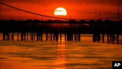 The sun sets behind a bridge over the Tigris River in Baghdad, Iraq.
