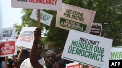 Um grupo de pessoas protesta contra o resultado das eleições presidenciais de 2023 e a emergência de Bola Tinubu como Presidente eleito em Abuja, Nigéria, a 1 de Março de 2023. 