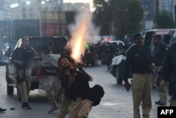 Police fire tear gas shells towards Pakistan Tehreek-e-Insaf (PTI) party activists and supporters of Pakistan's former prime minister Imran Khan during a protest against the arrest of their leader, in Karachi, May 9, 2023.