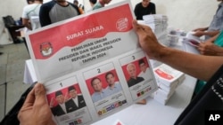 Seorang pekerja menunjukkan surat suara untuk pemilihan presiden pada 14 Februari nanti saat persiapan pembagian logistik pemilu di Tangerang, 10 Januari 2024. (Foto: Tatan Syuflana/AP Photo)