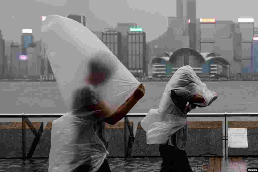 People brave strong winds as Super Typhoon Saola approaches, in Hong Kong.