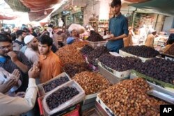 Warga Pakistan membeli kurma dan jajanan lainnya menjelang bulan suci Ramadan di Karachi, Maret 2023.