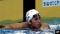 FILE - Janet Evans leans on the lane ropes after finishing the 400 meter freestyle at the 1996 Summer Olympics in Atlanta, July 22, 1996. Evans won four swimming golds at the 1988 and 1992 Games and recalls the never-easing pressure to perform.