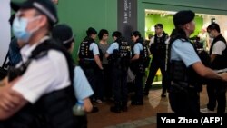 Polisi menggeledah artis Chan Meitung (tengah) di Causeway Bay dekat Victoria Park, di Hong Kong, Sabtu, 3 Juni 2023, sebelum kemudian dia ditahan, satu hari menjelang peringatan tragedi penumpasan gerakan pro-demokrasi di Lapangan Tiananmen, China pada 1989. (Foto: Yan Zhao/AFP)