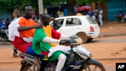 2023年8月11日，持俄罗斯和尼日尔国旗的尼日尔男子骑着摩托车参加尼亚美的反法抗议活动。（美联社照片）
