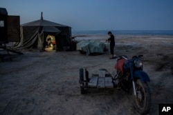 Men work in a yurt camp by the dried-up Aral Sea, outside Muynak, Uzbekistan, June 25, 2023.