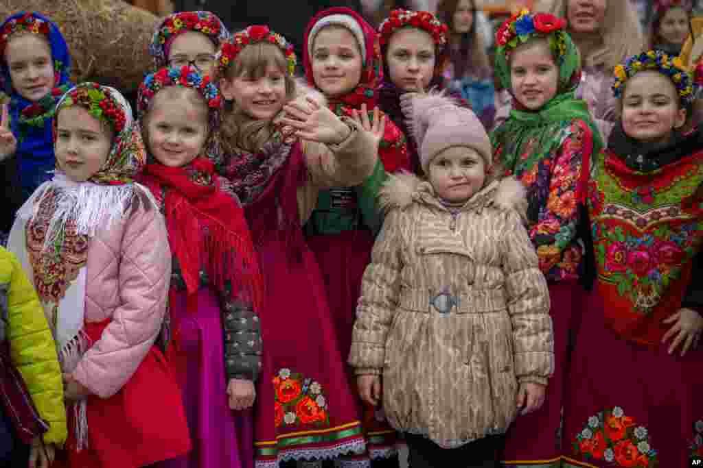 Children wearing traditional outfits are seen before performing songs during a show of traditions for Masnytsia, a holiday that originates in pagan times, celebrating the end of winter, in Kyiv, Ukraine, March 16, 2024.