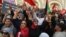 Demonstrators chant slogans while lifting Tunisian and Palestinian flags at a rally organized by the National Salvation Front opposition alliance in Tunis, May 12, 2024, to call for the release of arrested opposition figures. 