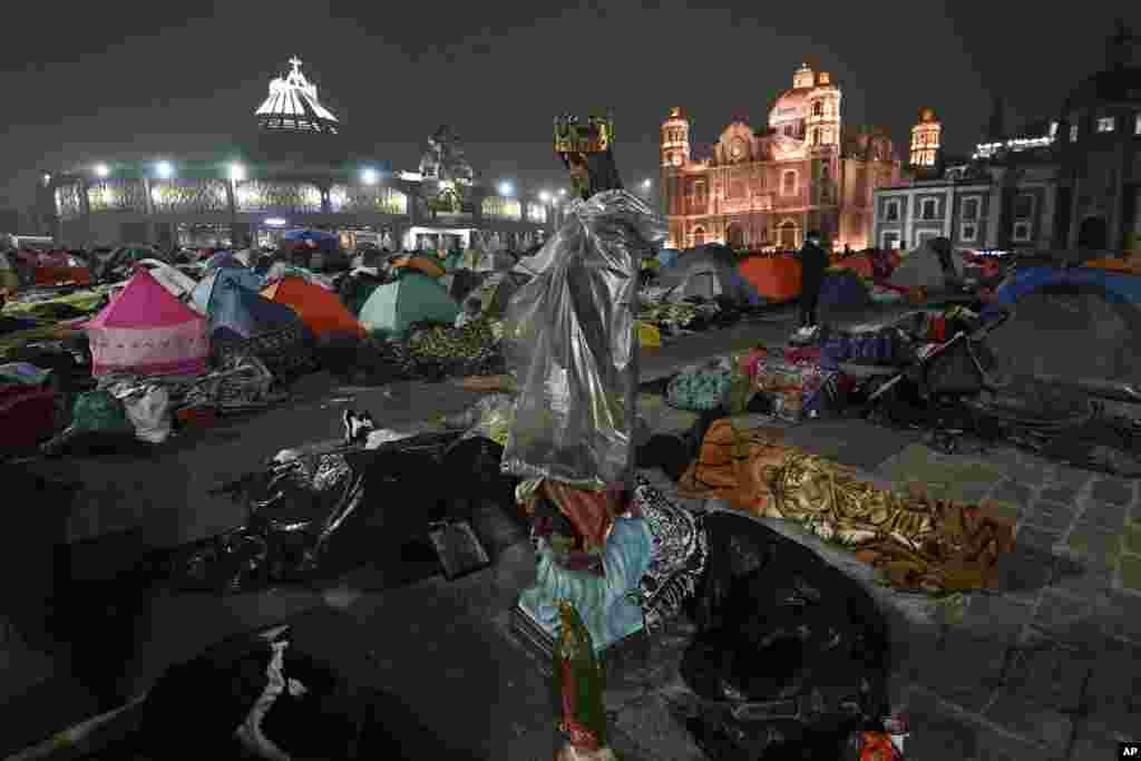 A statue of the Virgin of Guadalupe stands amid pilgrims sleeping outside the Basilica of Guadalupe on her feast day in Mexico City. (AP Photo/Marco)