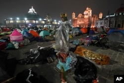 FILE - A statue of the Virgin of Guadalupe stands amid pilgrims sleeping outside the Basilica of Guadalupe on her feast day in Mexico City, Dec. 12, 2023. (AP Photo/Marco Ugarte)