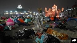 A statue of the Virgin of Guadalupe stands amid pilgrims sleeping outside the Basilica of Guadalupe on her feast day in Mexico City. (AP Photo/Marco)