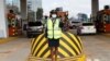 FILE - A traffic controller directs motorists driving past a toll station on the newly opened Expressway built by the China Road and Bridge Corporation (CRBC) on a public-private partnership (PPP) basis, in Nairobi, Kenya, May 14, 2022. 