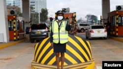 FILE - A traffic controller directs motorists driving past a toll station on the newly opened Expressway built by the China Road and Bridge Corporation (CRBC) on a public-private partnership (PPP) basis, in Nairobi, Kenya, May 14, 2022. 
