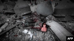 A Palestinian girl wearing a pink dress stands amidst the ruins of the Al-Faruq Mosque that was destroyed during Israeli bombardment, in Rafah on the southern Gaza Strip. (Photo by MOHAMMED ABED / AFP)