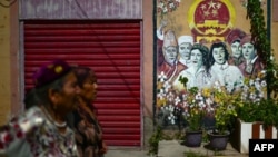 FILE - This picture taken July 14, 2023, shows Uyghur women walking through a neighborhood in Kashgar city in northwestern China's Xinjiang region. 