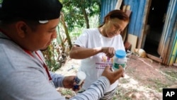 Lourdes Betancourt prepares a jar containing mosquito eggs to hang from a tree in her yard, in Tegucigalpa, Honduras, Aug. 23, 2023. The mosquitoes that hatch will carry bacteria called Wolbachia that interrupt the transmission of dengue. (AP Photo/Elmer Martinez)