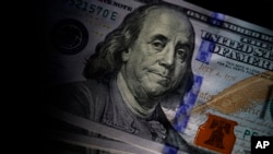 FILE - The likeness of Benjamin Franklin is seen on US $100 bills, July 14, 2022, in Marple Township, Pa.