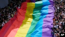 ແຟ້ມພາບ - ພວກຄົນທີ່ເຂົ້າຮ່ວມໃນຂະບວນແຫ່ທີ່ເອີ້ນວ່າ Pride Parade ໃນບາງກອກພາກັນຈັບທຸງຫຼາຍສີທີ່ເປັນສັນຍາລັກ ຂອງກຸ່ມ LGBT, ຢູ່ປະເທດໄທ, ເມື່ອວັນທີ 4 ມິຖຸນາ 2023. 