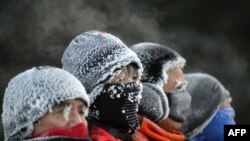 Penutup kepala yang dikenakan para warga di Shenyang, China, tertutup oleh embun yang membeju ketika mereka beraktivitas di luar ruangan pada 20 Desember 2023. (Foto: AFP)