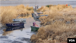 Los boteros tienen que arreglárselas para tratar de entrar a los canales cada vez más secos del lago y poder descargar productos o personas.