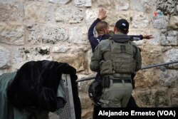 Un policía israelí revisa a un joven palestino en la Puerta de los Leones, uno de los accesos a la Ciudad Vieja de Jerusalén, por donde transitan miles de musulmanes que se dirigen a orar en la Explanada de las Mezquitas.