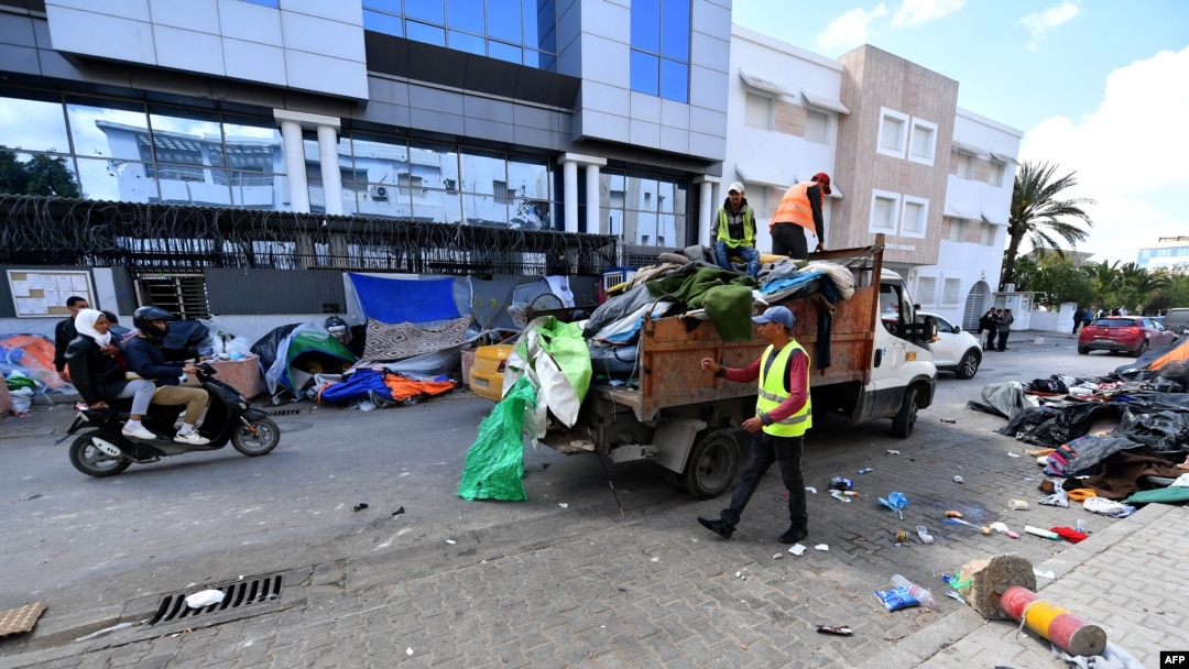 FILE: Municipal workers remove material from a makeshift camp for migrants and refugees from sub-Saharan African countries after it was dismantled by the police, in front of the U.N. High Commission for Refugees headquarters in Tunis, on April 11, 2023.