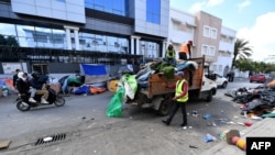 FILE: Municipal workers remove material from a makeshift camp for migrants and refugees from sub-Saharan African countries after it was dismantled by the police, in front of the U.N. High Commission for Refugees headquarters in Tunis, on April 11, 2023.