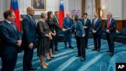 In this photo released by the Taiwan Presidential Office, visiting Australian lawmakers are greeted by Taiwan's President Tsai Ing-wen at the Presidential Office in Taipei, Taiwan, Sept. 26, 2023. 