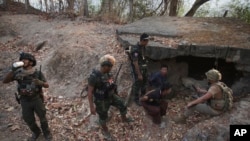 Members of the Karen National Liberation Army and People’s Defense Force interrogate two arrested soldiers after they captured an army outpost, in the southern part of Myawaddy township in Kayin state, Myanmar, March 11, 2024. 