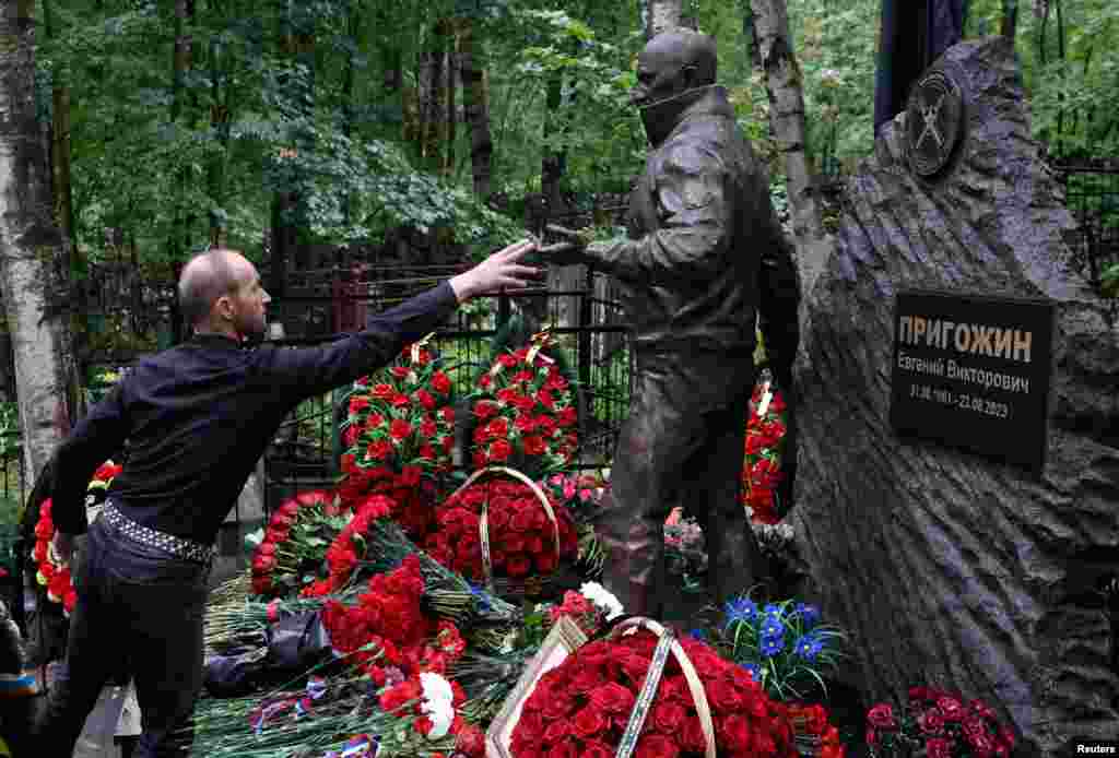 Seorang pria mengunjungi makam komandan tentara bayaran Rusia Yevgeny Prigozhin pada peringatan tahun pertama kematiannya dalam kecelakaan pesawat, di pemakaman Porokhovskoye di Saint Petersburg, Rusia. (Reuters)&nbsp;