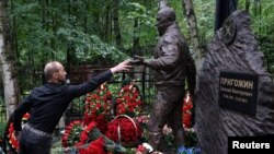 A man visits the grave of Russian mercenary chief Yevgeny Prigozhin on the first anniversary of his death from a plane crash, at the Porokhovskoye cemetery in Saint Petersburg, Russia.