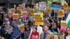 People hold signs at a protest against racism outside Reform UK's headquarters in Westminster, in London, Aug. 10, 2024.