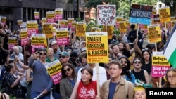 People hold signs at a protest against racism outside Reform UK's headquarters in Westminster, in London, Aug. 10, 2024.