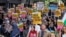 People hold signs at a protest against racism outside Reform UK's headquarters in Westminster, in London, Aug. 10, 2024.
