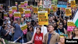 FILE: People hold signs at a protest against racism outside Reform UK's headquarters in Westminster, in London, Aug. 10, 2024.