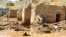 An Afghan man collects his belongings from his damaged home after heavy flooding in Ghor province in western Afghanistan, May 18, 2024. 