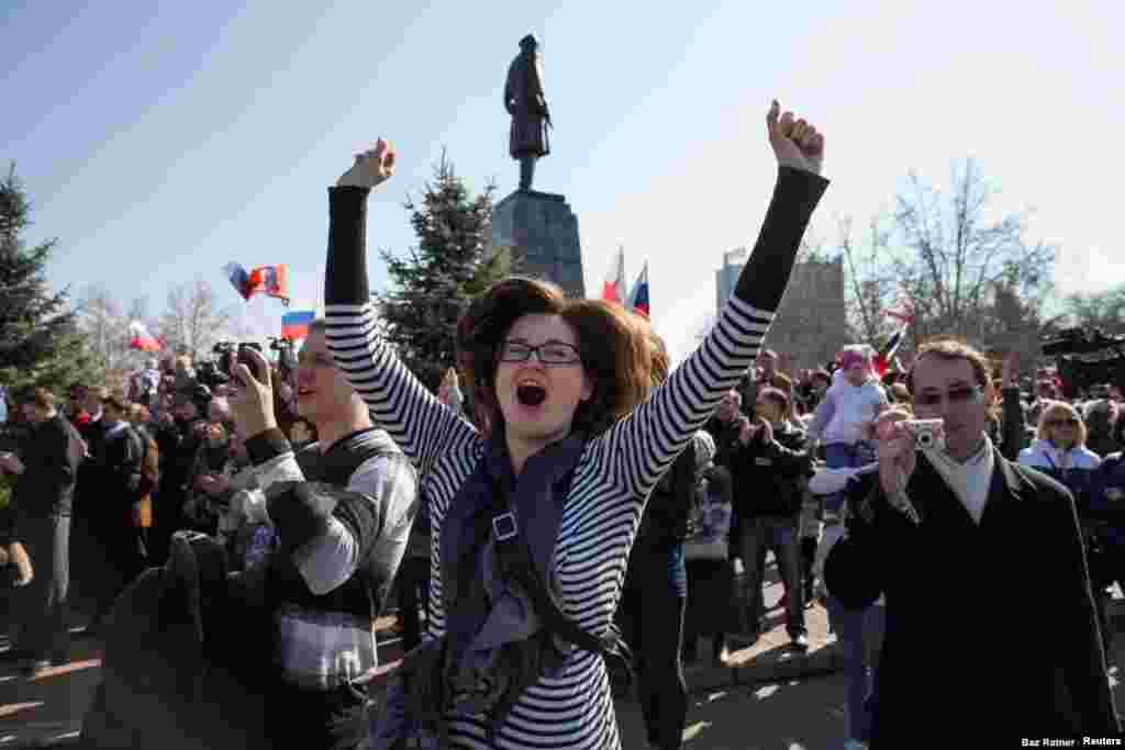 Una mujer celebra en Sebastopol el 18 de marzo, mientras una multitud mira una transmisión en vivo del presidente ruso tras los resultados del controvertido referendo. Putin se dirigió a los crimeos como &ldquo;ciudadanos de Rusia&rdquo; durante el discurso.
