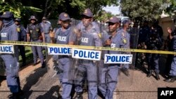 FILE — South African Police Service officers prepare riot gear for a protest in front of the presidential Guest House in Pretoria, March 20, 2023.