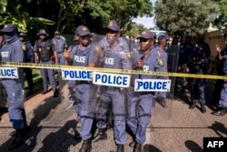 South African Police Service officers prepare riot gear as Economic Freedom Fighters (EFF) protest in front of the presidential guest house in Pretoria on March 20, 2023 during a national shutdown called by their party.