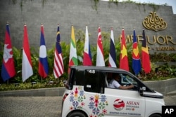 Seorang pengendara mobil listrik melintas di depan lokasi pertemuan puncak Perhimpunan Bangsa-Bangsa Asia Tenggara (ASEAN) di Labuan Bajo, 9 Mei 2023. (Foto: Bayu Ismoyo/Pool Photo via AP)