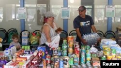 FILE - Pusat sumbangan makanan dan persediaan untuk membantu orang-orang yang terkena dampak banjir dan badai di klub bowling lokal di barat laut Sydney, Wisemans Ferry, Australia, 25 Maret 2021. (REUTERS/Loren Elliott)