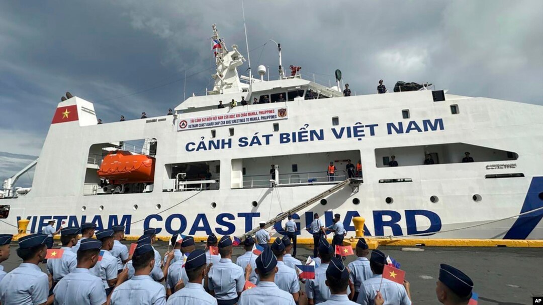 Philippine Coast Guard personnel wave Vietnamese and Filipino flags to welcome the Vietnam Coast Guard ship CSB 8002 in Manila, Philippines, Aug. 5, 2024.
