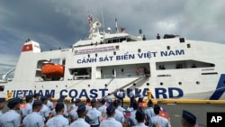 Philippine Coast Guard personnel wave Vietnamese and Filipino flags to welcome the Vietnam Coast Guard ship CSB 8002 in Manila, Philippines, Aug. 5, 2024.