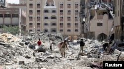 Palestinians inspect damage in Qatari-funded Hamad City following an Israeli raid in Khan Younis in the southern Gaza Strip, Aug. 24, 2024.