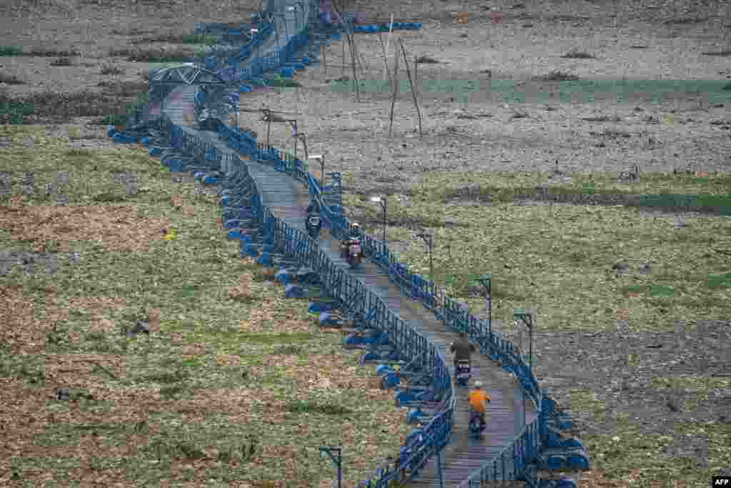 People pass on a floating bridge that some 300m across the dried up Citarum River in Cihampelas, West Java, Indonesia.