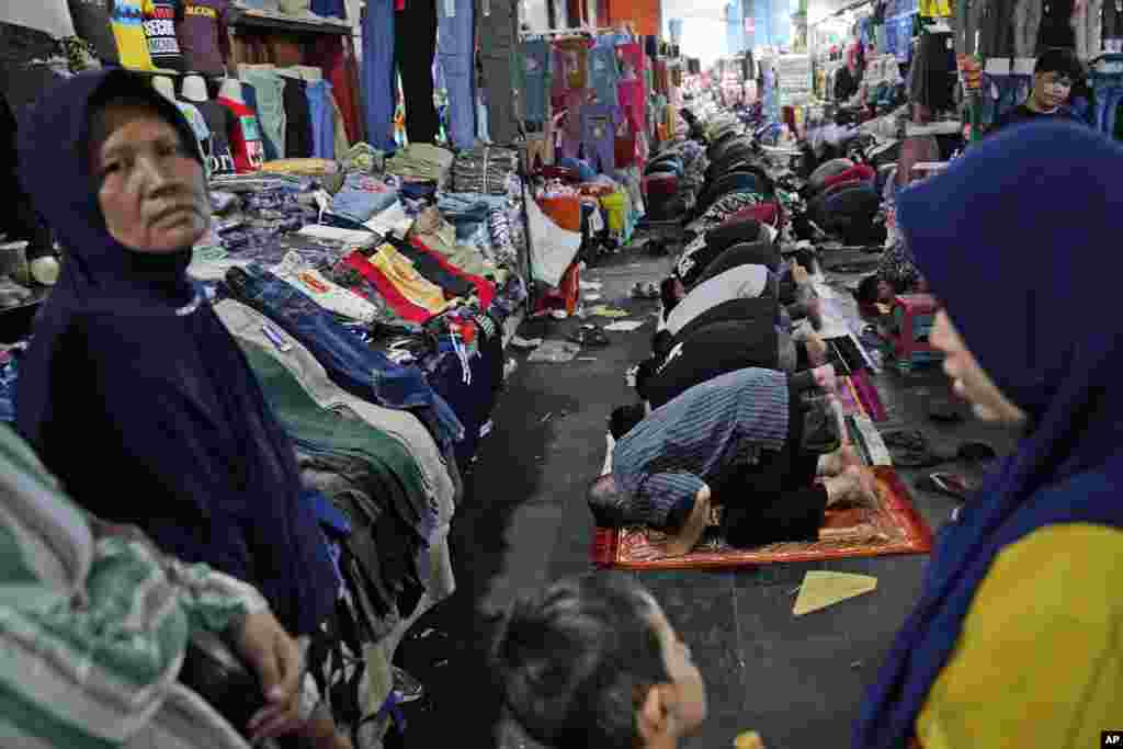 جکارتہ کی ایک مارکیٹ میں لوگ نمازِ جمعہ ادا کر رہے ہیں۔ اس دوران بازار کھلا ہوا ہے۔