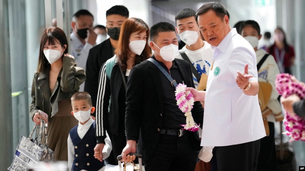 资料照片：泰国素万那普国际机场，泰国公共卫生部长阿努廷·查恩维拉库（Anutin Charnvirakul）向抵达机场的中国游客赠送花环。（2023年1月9日）(photo:VOA)