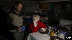 Local residents take shelter, living in a basement in the village of Chasiv Yar, near the city of Bakhmut, in Ukraine's Donbas region, March 5, 2023.